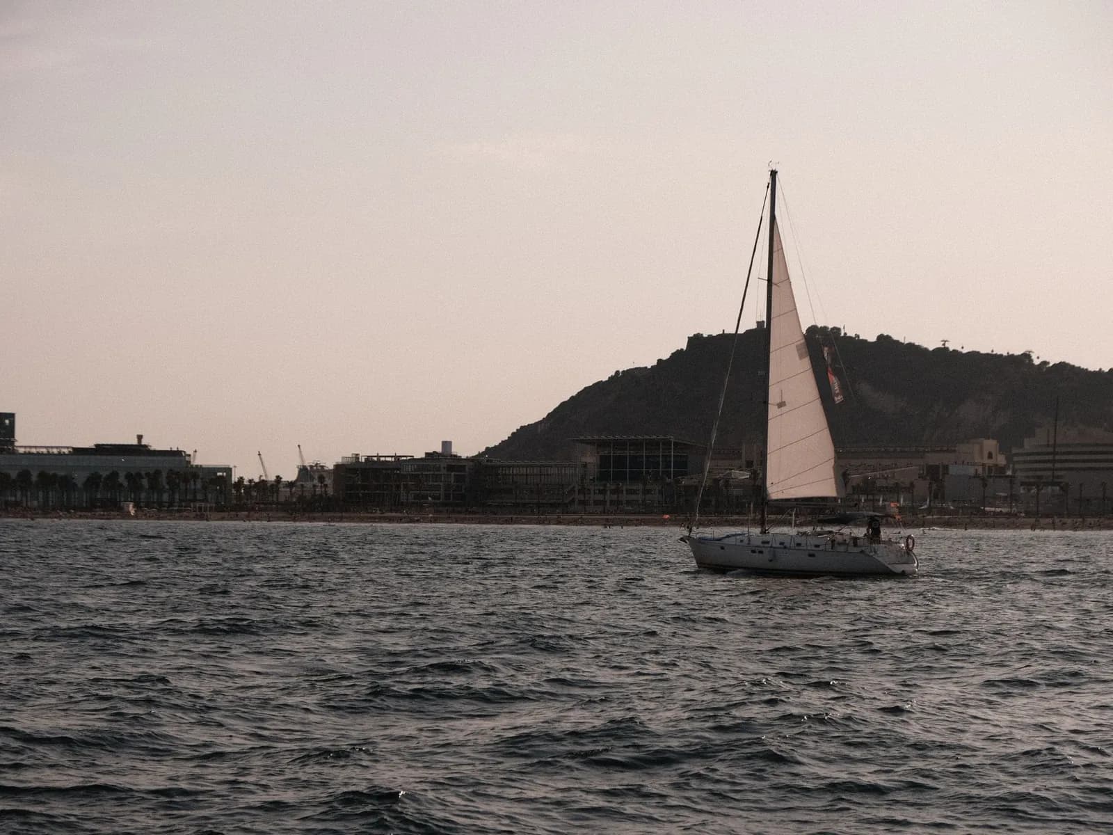 Sailboat at sunset off the Barcelona coast