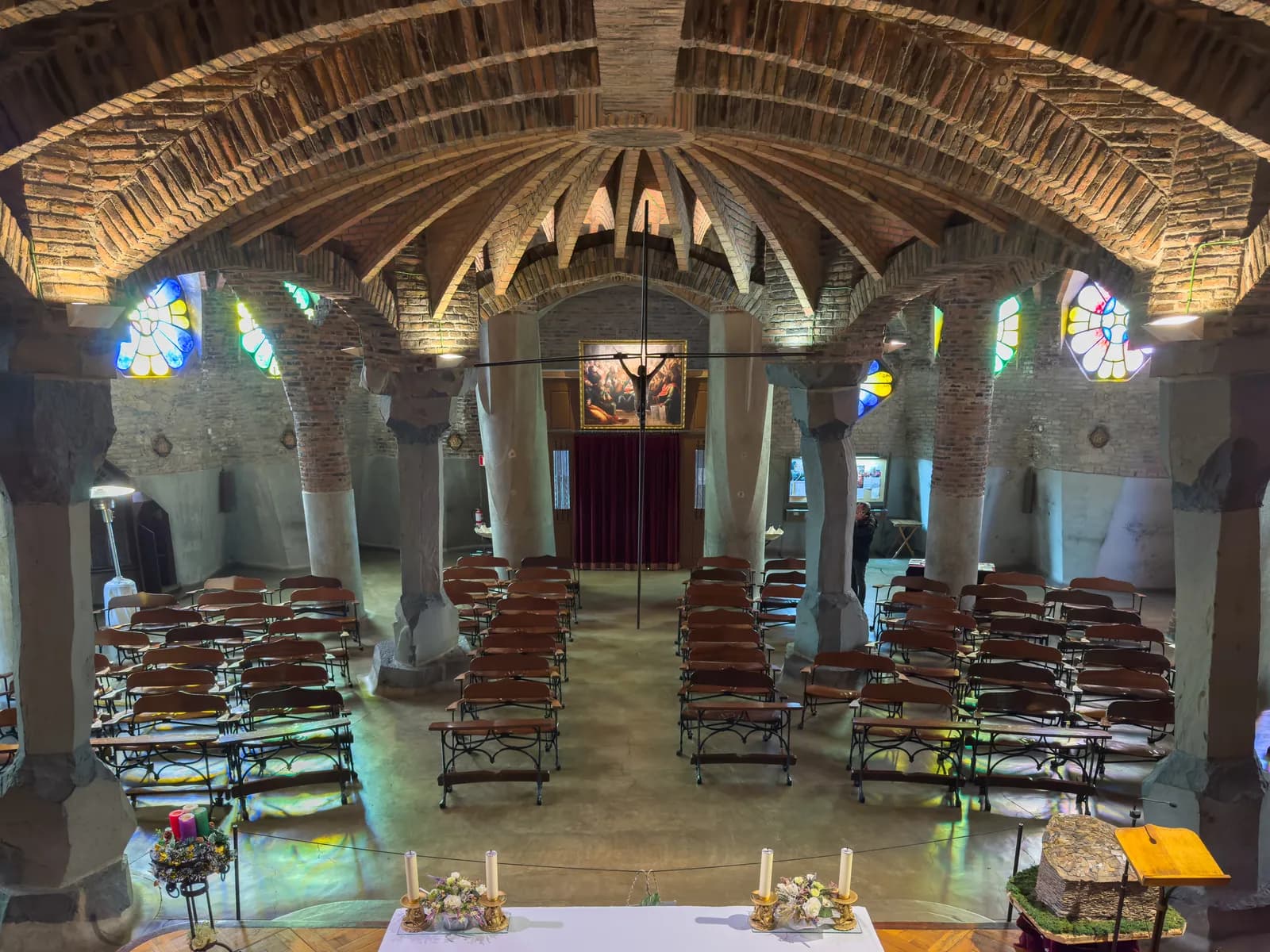 Interior de la Cripta de la Colonia Güell, con columnas inclinadas y bancos de Gaudí