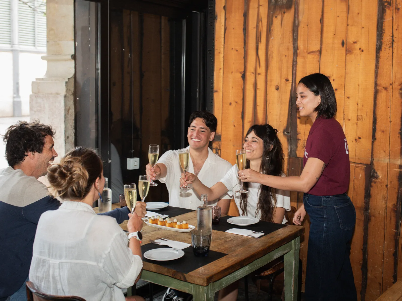 Guía sirviendo cava a un grupo en la mesa de una bodega