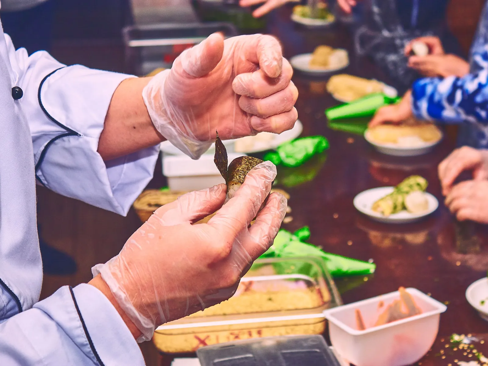 Manos preparando comida en una clase de cocina