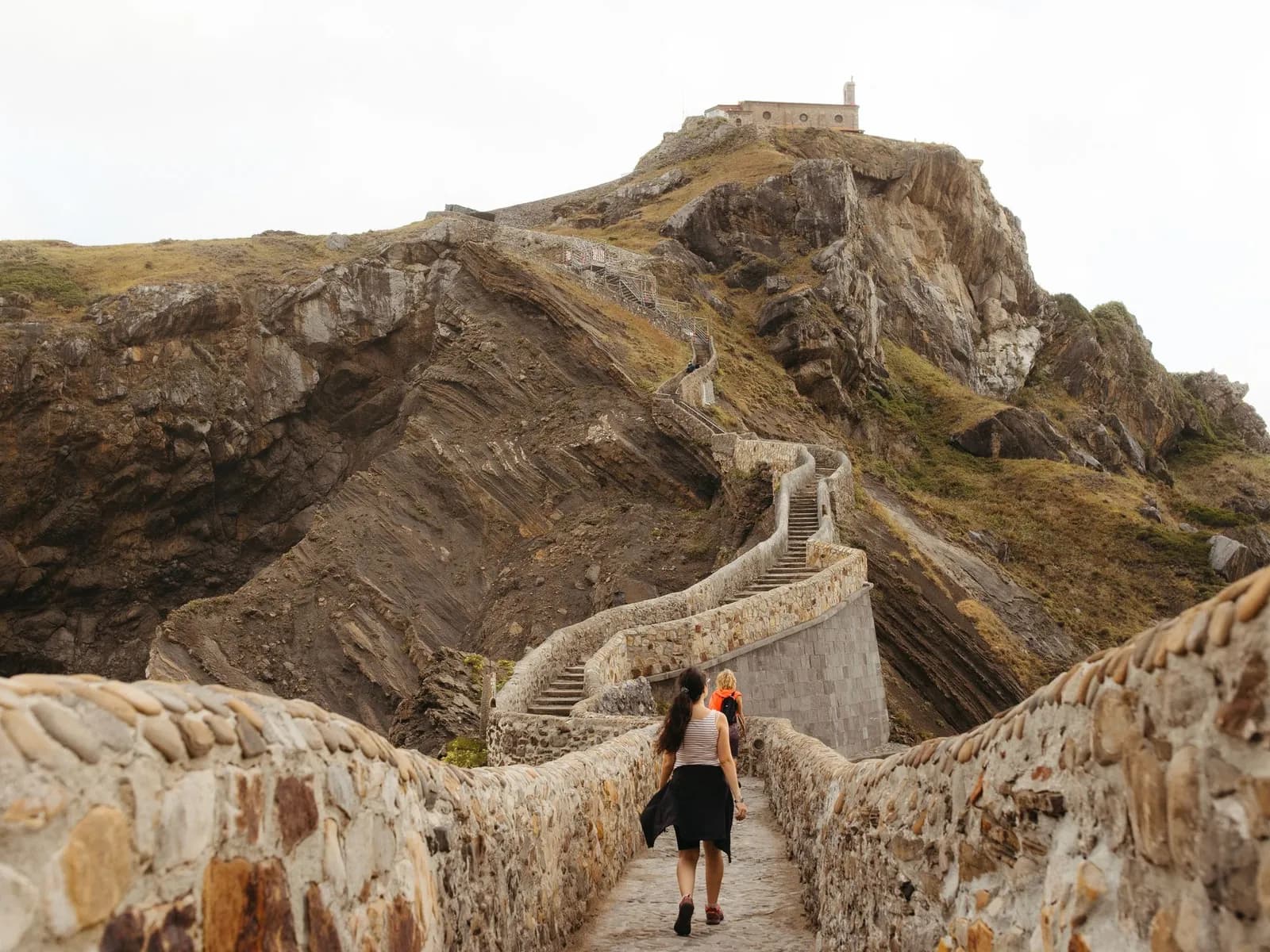 Caminante subiendo las escaleras de piedra de San Juan de Gaztelugatxe