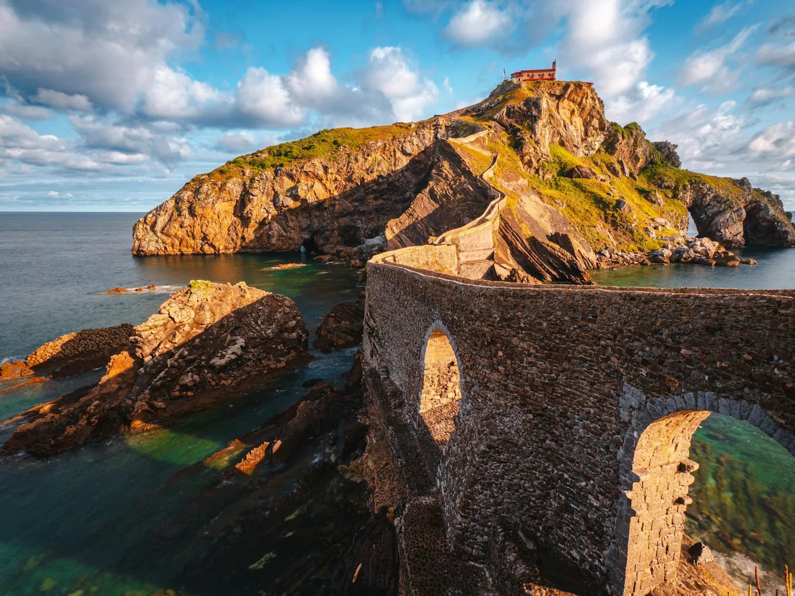 Stone bridge to San Juan de Gaztelugatxe in golden light