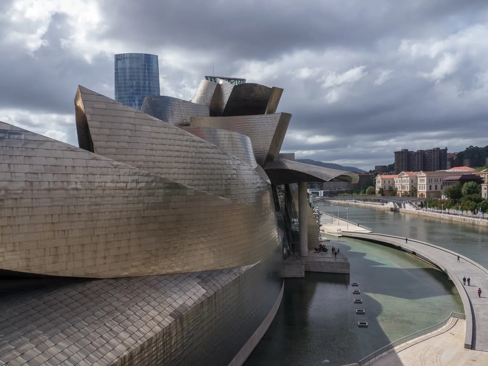 Titanium facade of the Guggenheim Bilbao over the pool by the river