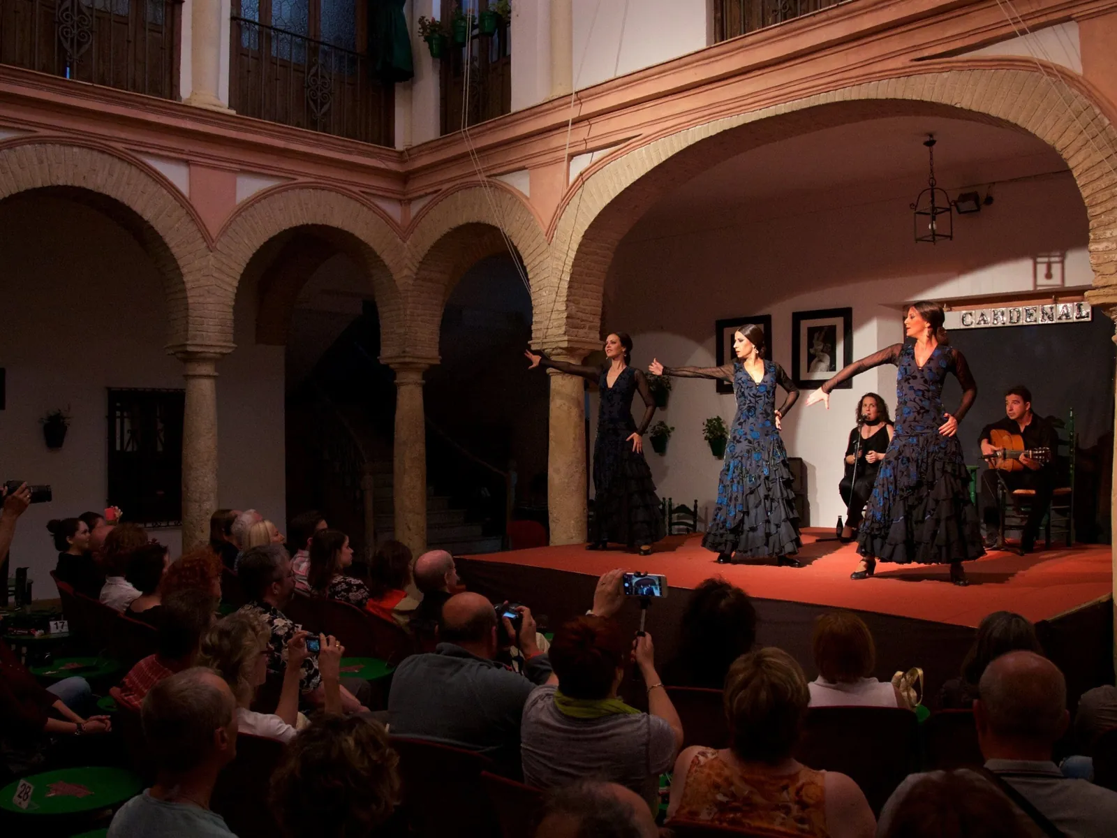 Tres bailaoras de azul en el patio del Tablao El Cardenal, en Córdoba