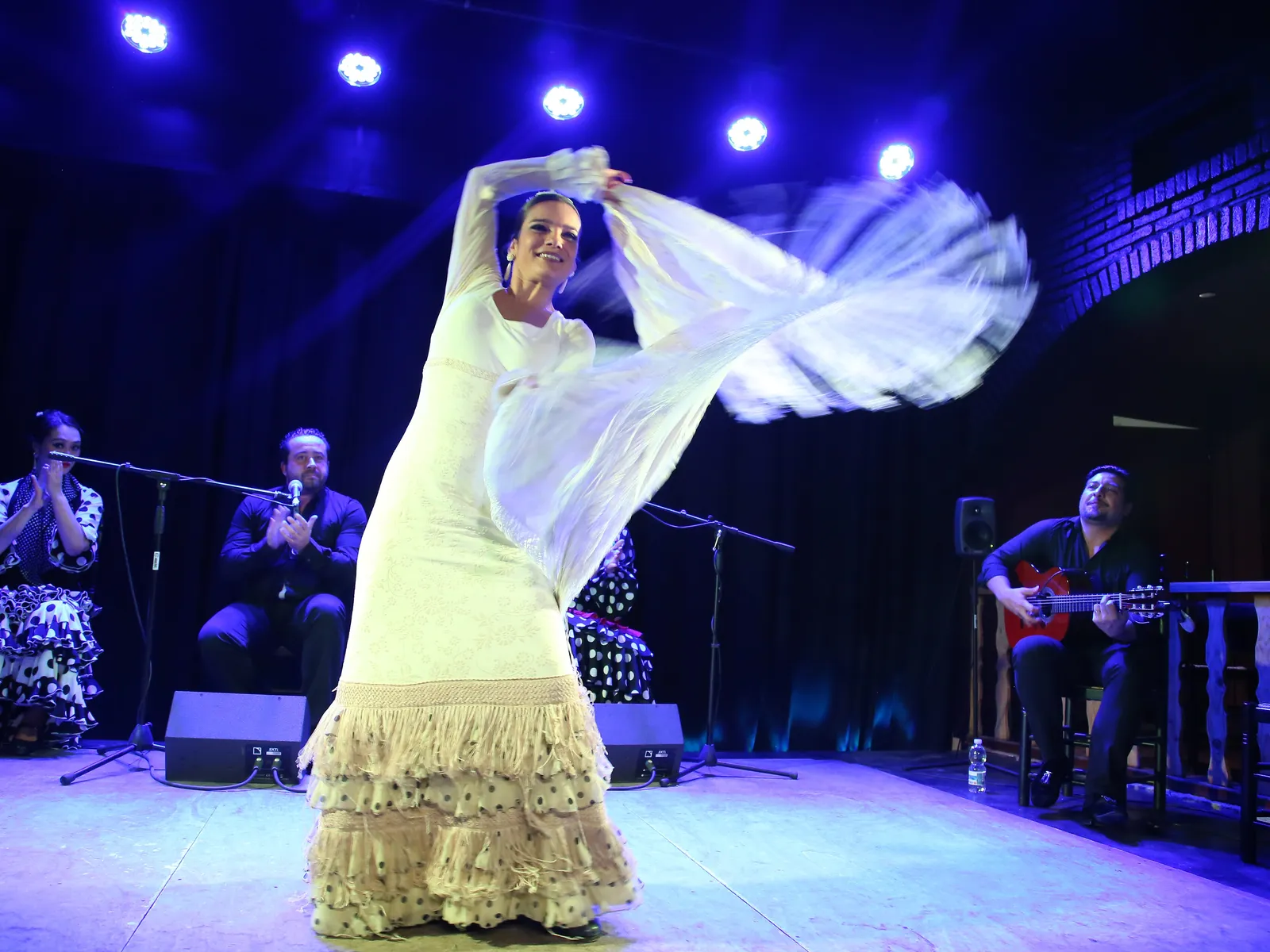Flamenco dancer with a white shawl during a flamenco show