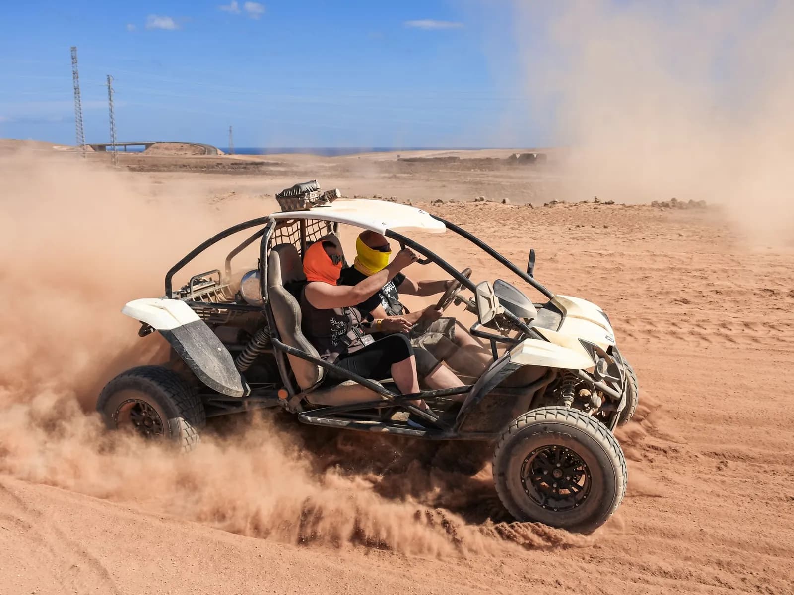 Buggy kicking up dust on a dirt track in Corralejo
