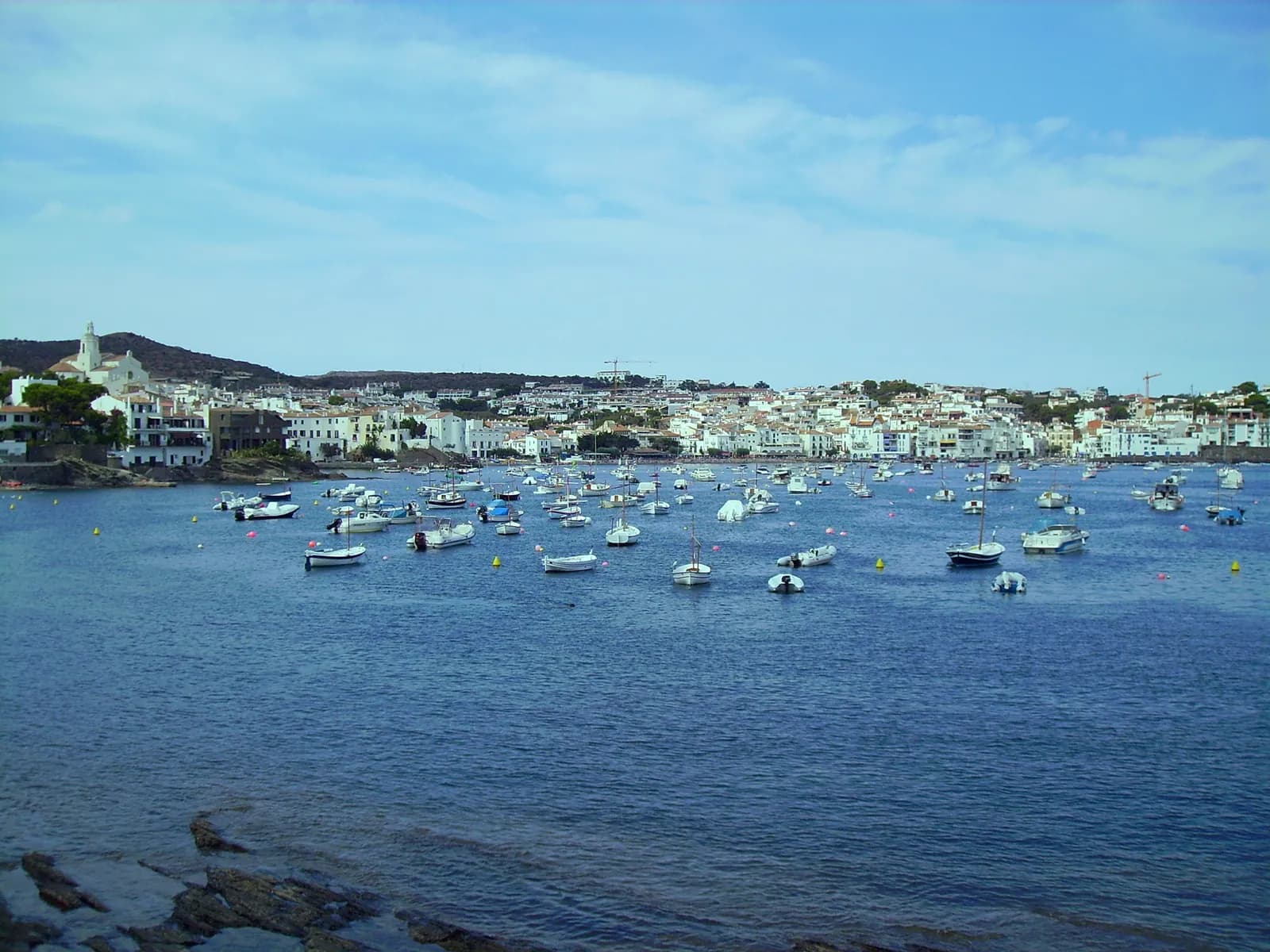 Bahía de Cadaqués con barcas fondeadas y el pueblo blanco al fondo