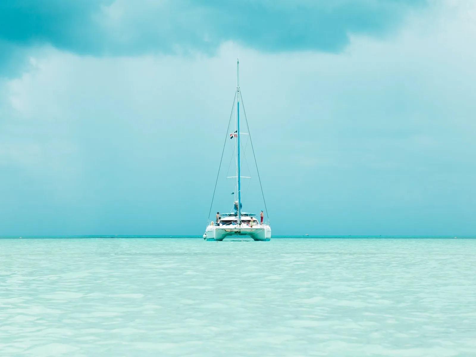 A catamaran anchored in clear water for swimming