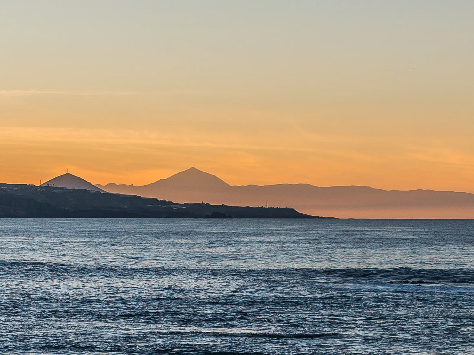 Atardecer sobre el Atlántico desde la costa norte de Gran Canaria, con el Teide en el horizonte