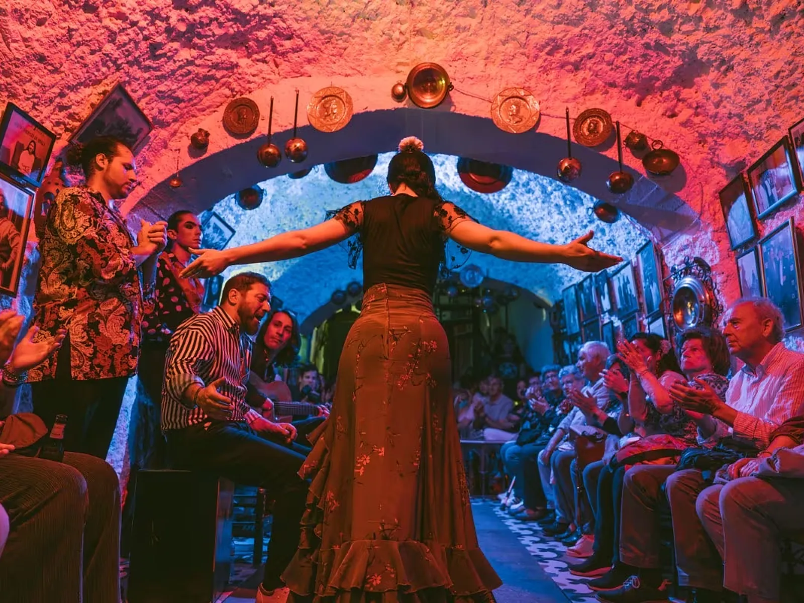 Dancer in the middle of Cueva Los Amayas with the audience on both sides