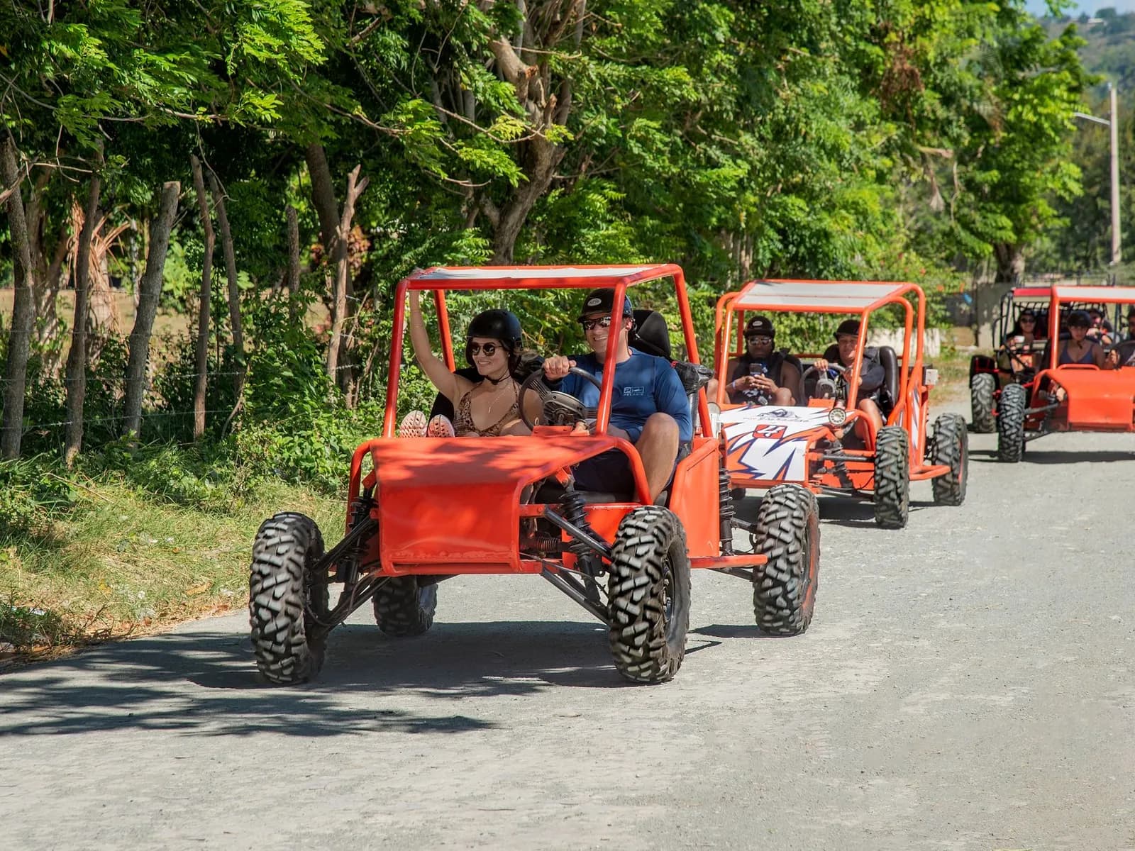 Grupo de buggies todoterreno en ruta por un camino entre árboles