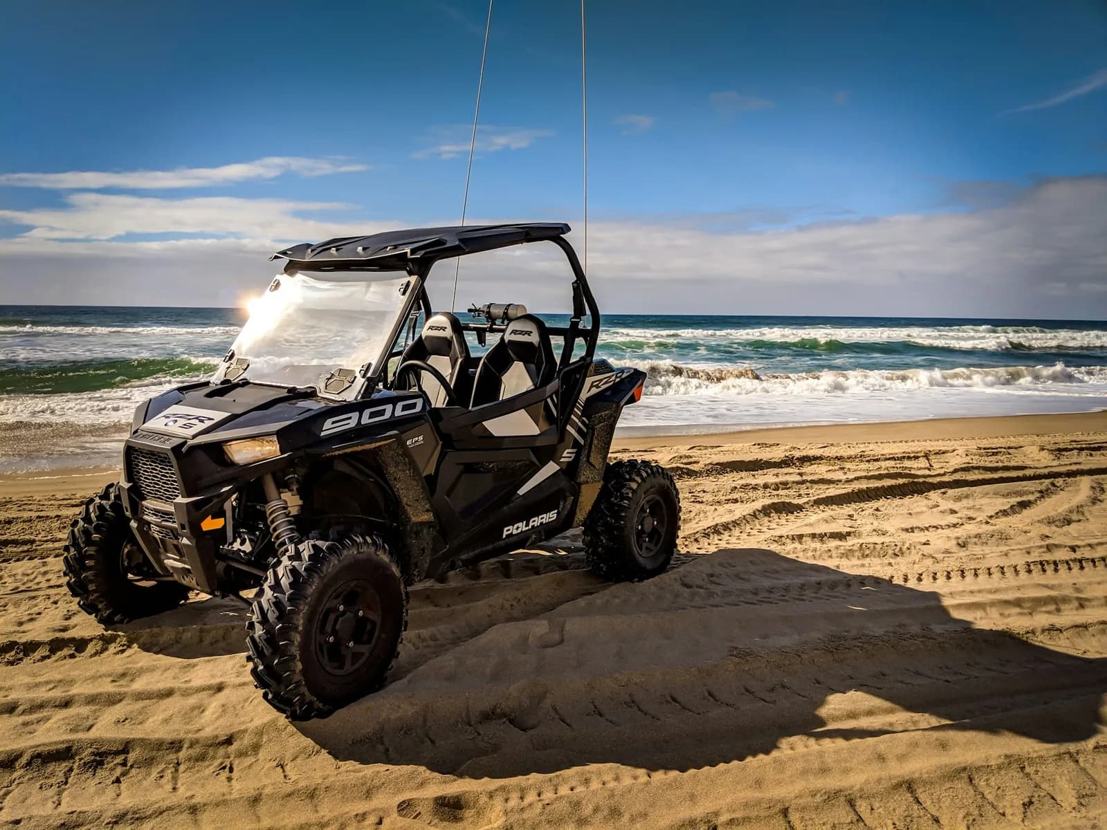 Polaris buggy parked by the sea