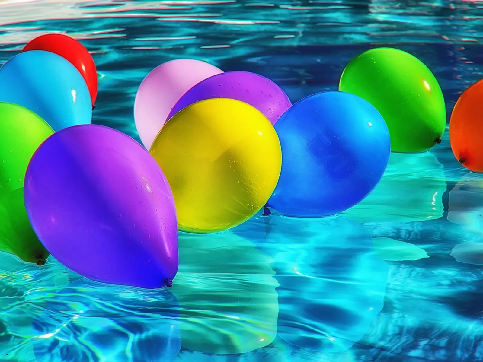 Globos de colores flotando en una piscina