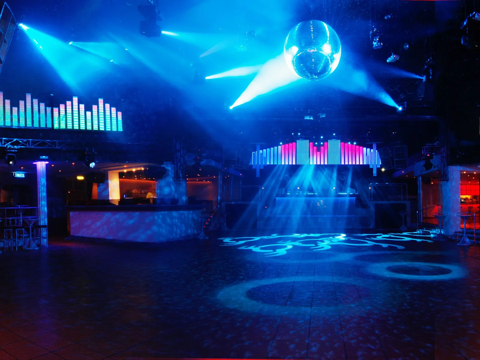 Pista de baile de una discoteca con bola de espejos y focos