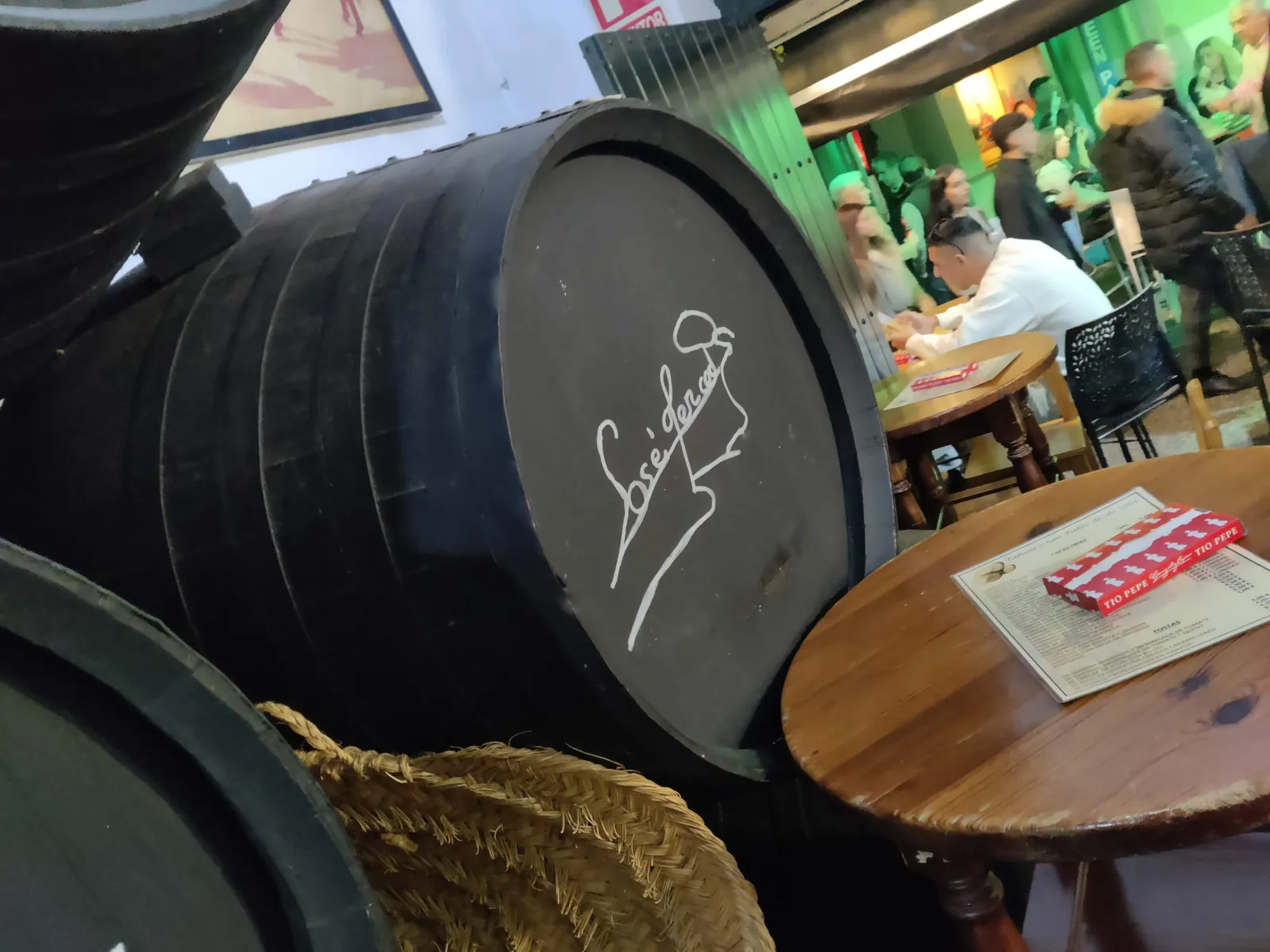Bota de vino de Jerez firmada en un tabanco lleno de clientes