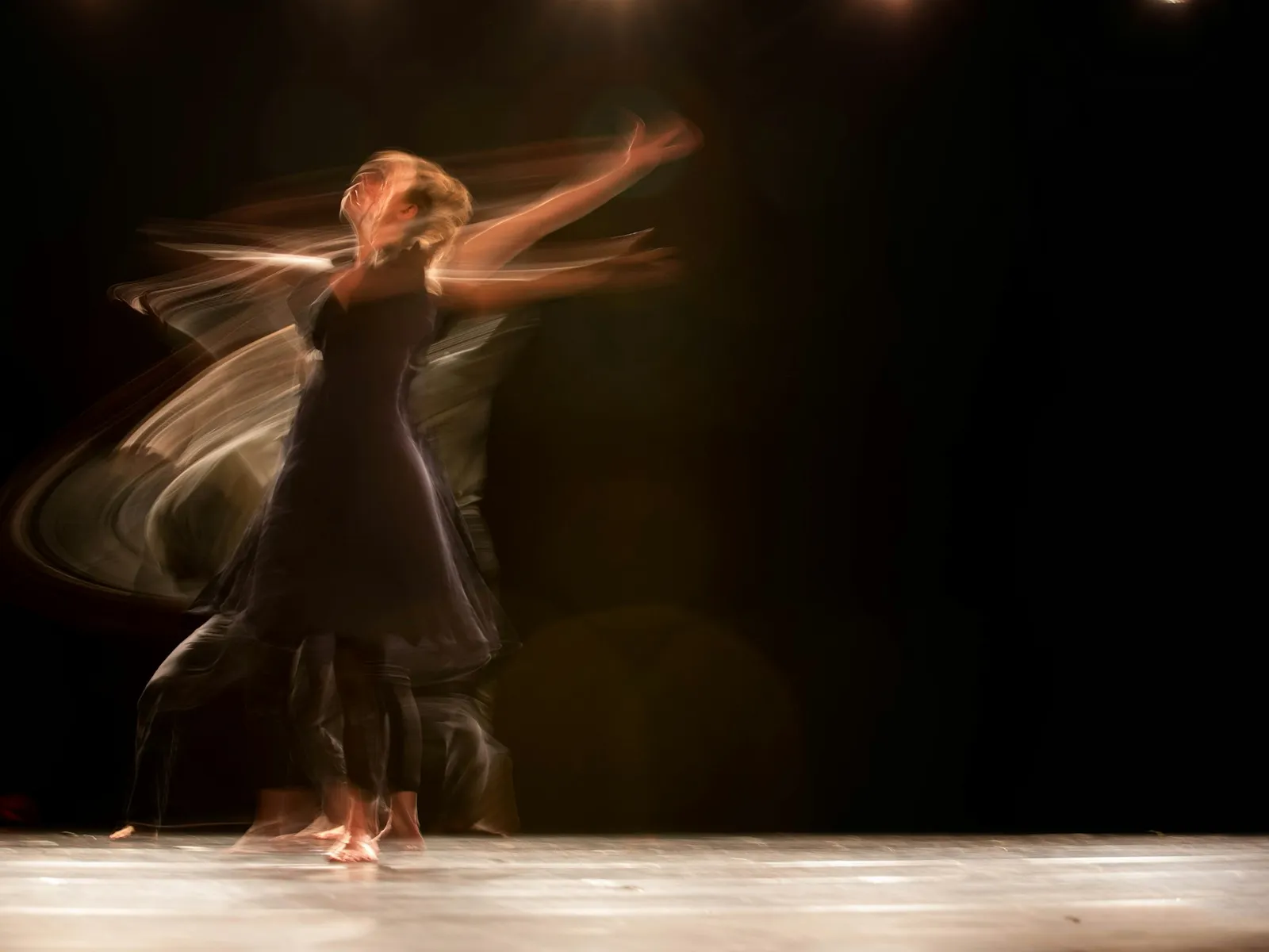 Flamenco dancer in motion on a dark stage