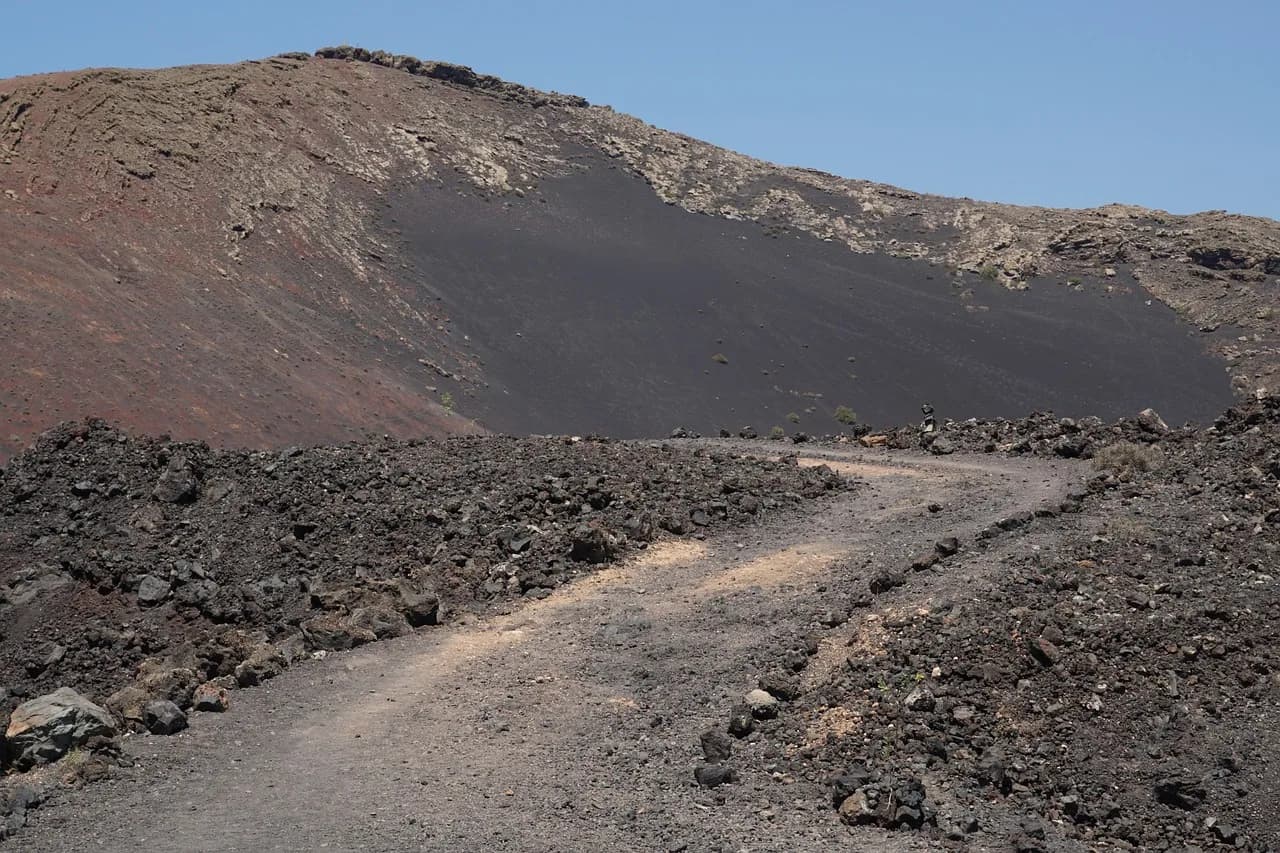 Hikers walking among volcanic cones in Lanzarote