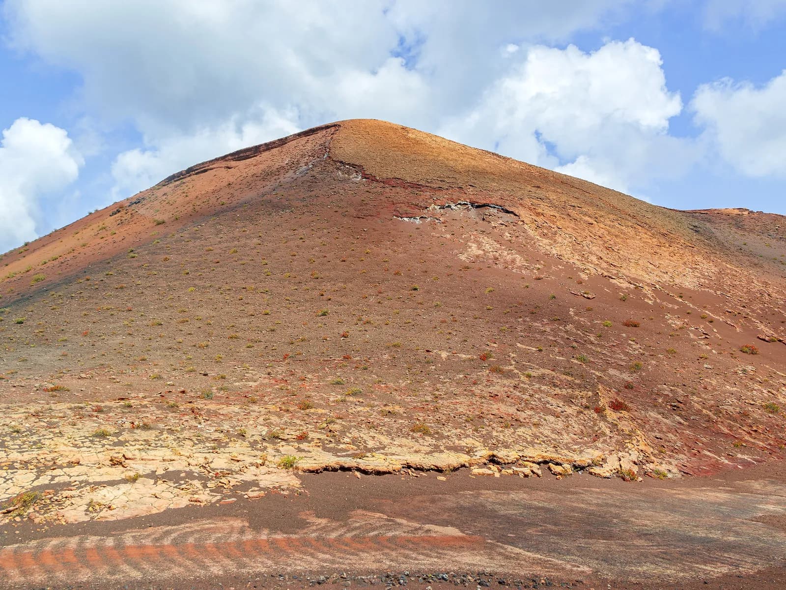 Volcán rojizo bajo las nubes en Timanfaya