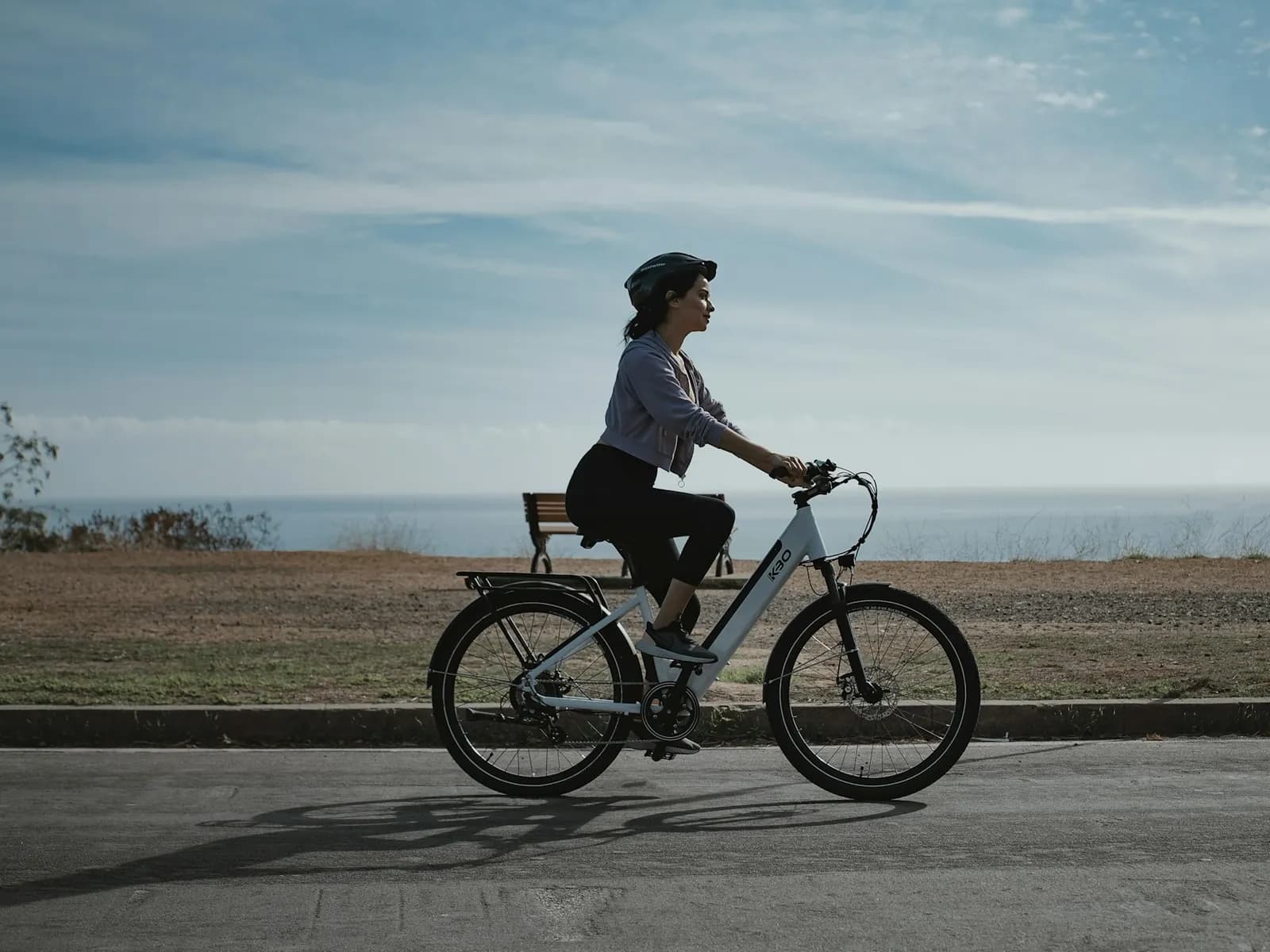 Ciclista en bicicleta eléctrica con el mar al fondo