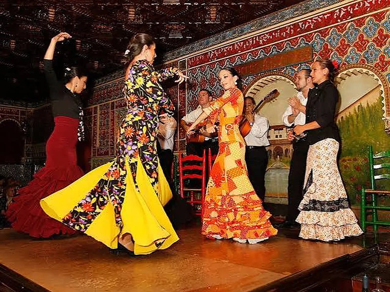 Flamenco dancers performing on stage at Tablao Torres Bermejas, with its Alhambra-inspired decor