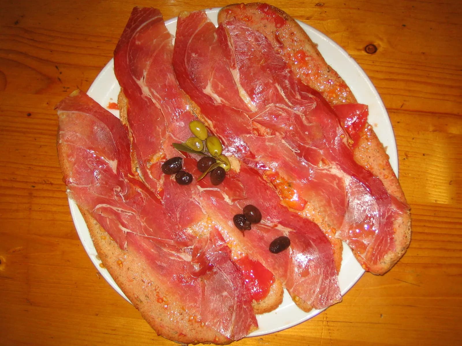 Tapa de jamón sobre pan con tomate