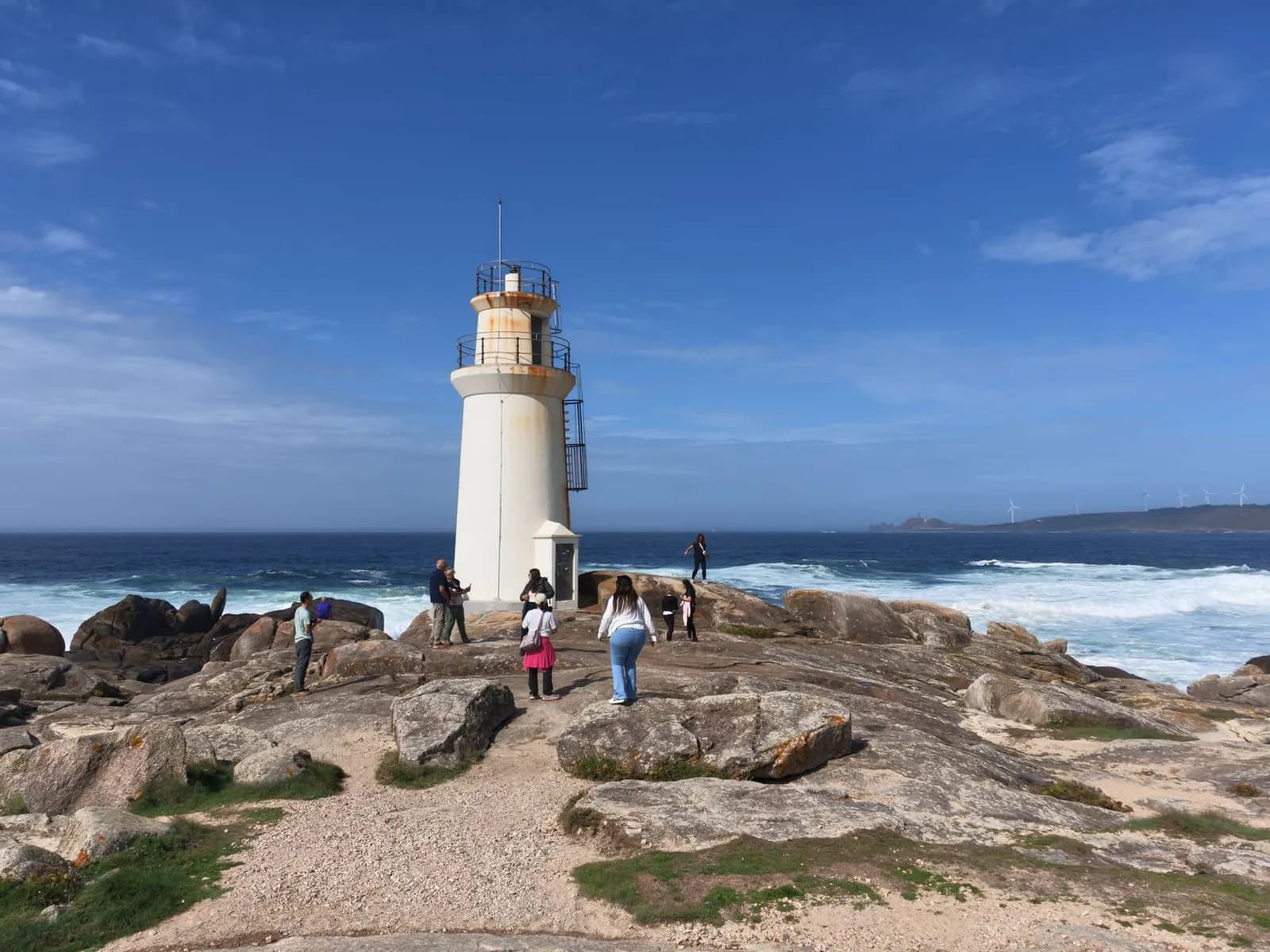 Visitors on the rocks beside Muxía lighthouse, Costa da Morte