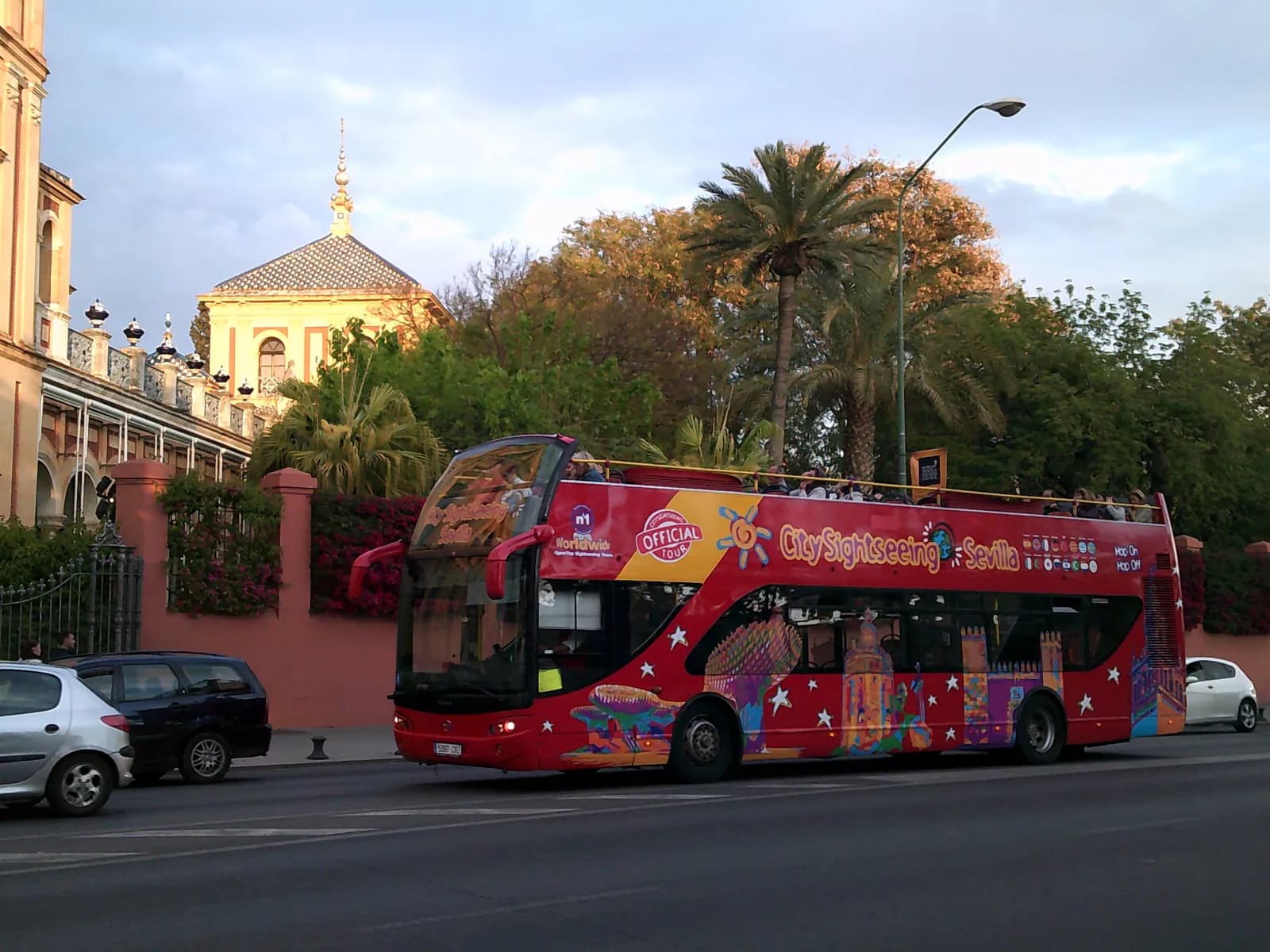 Red City Sightseeing tour bus driving through Seville