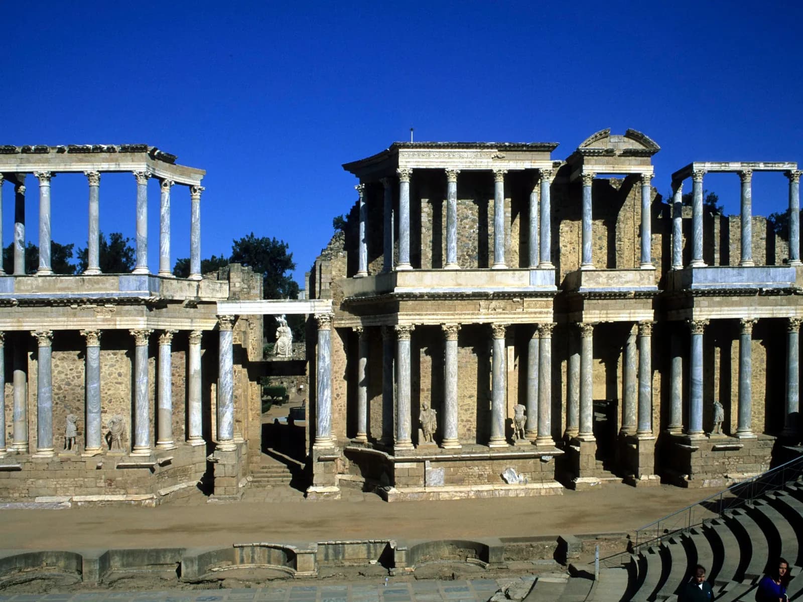 Escena columnada del teatro romano de Mérida bajo un cielo azul intenso