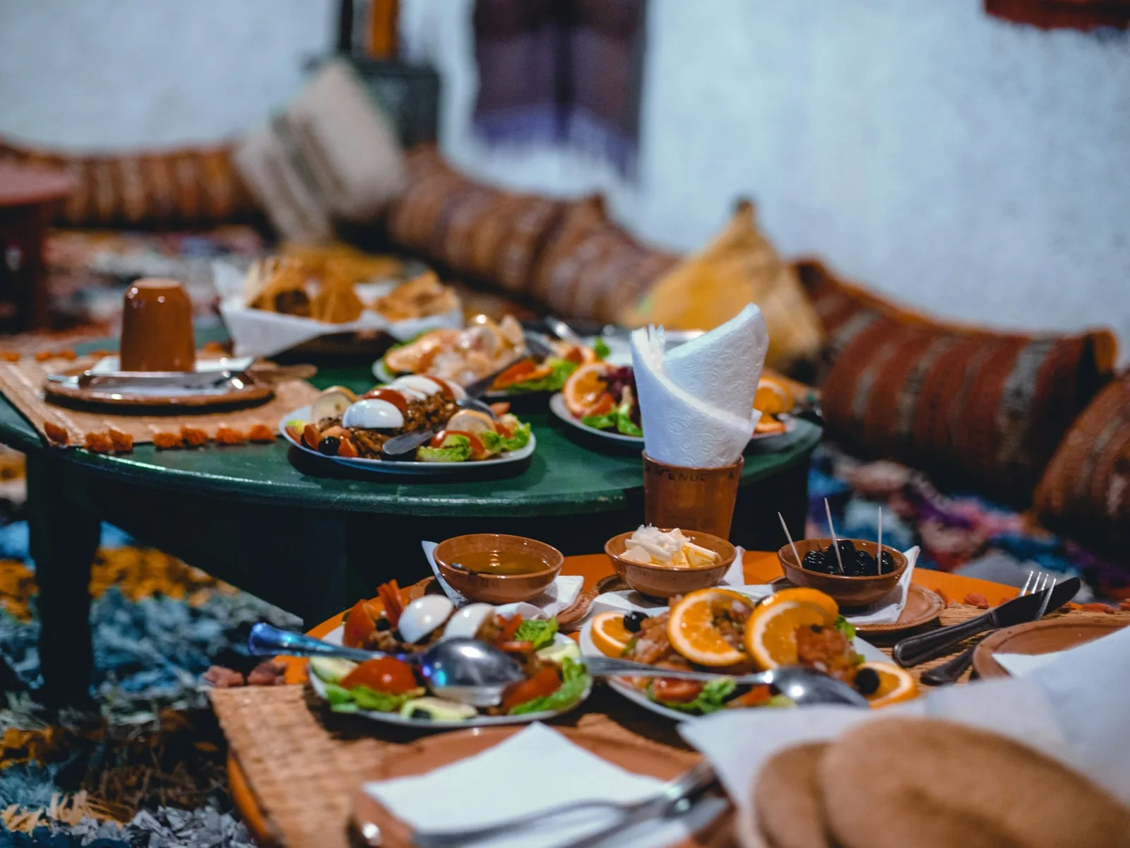 Tajín, té de menta y pan en mesa de restaurante marroquí tradicional de Sevilla con platos coloridos