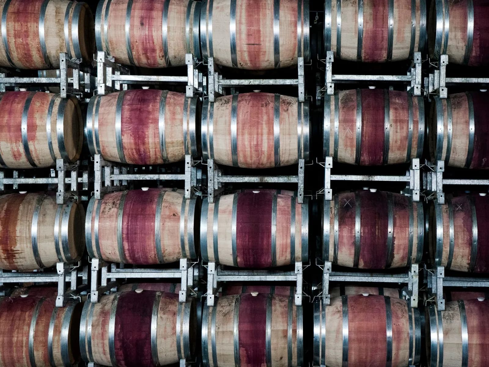 Oak barrels of red wine stacked in a winery