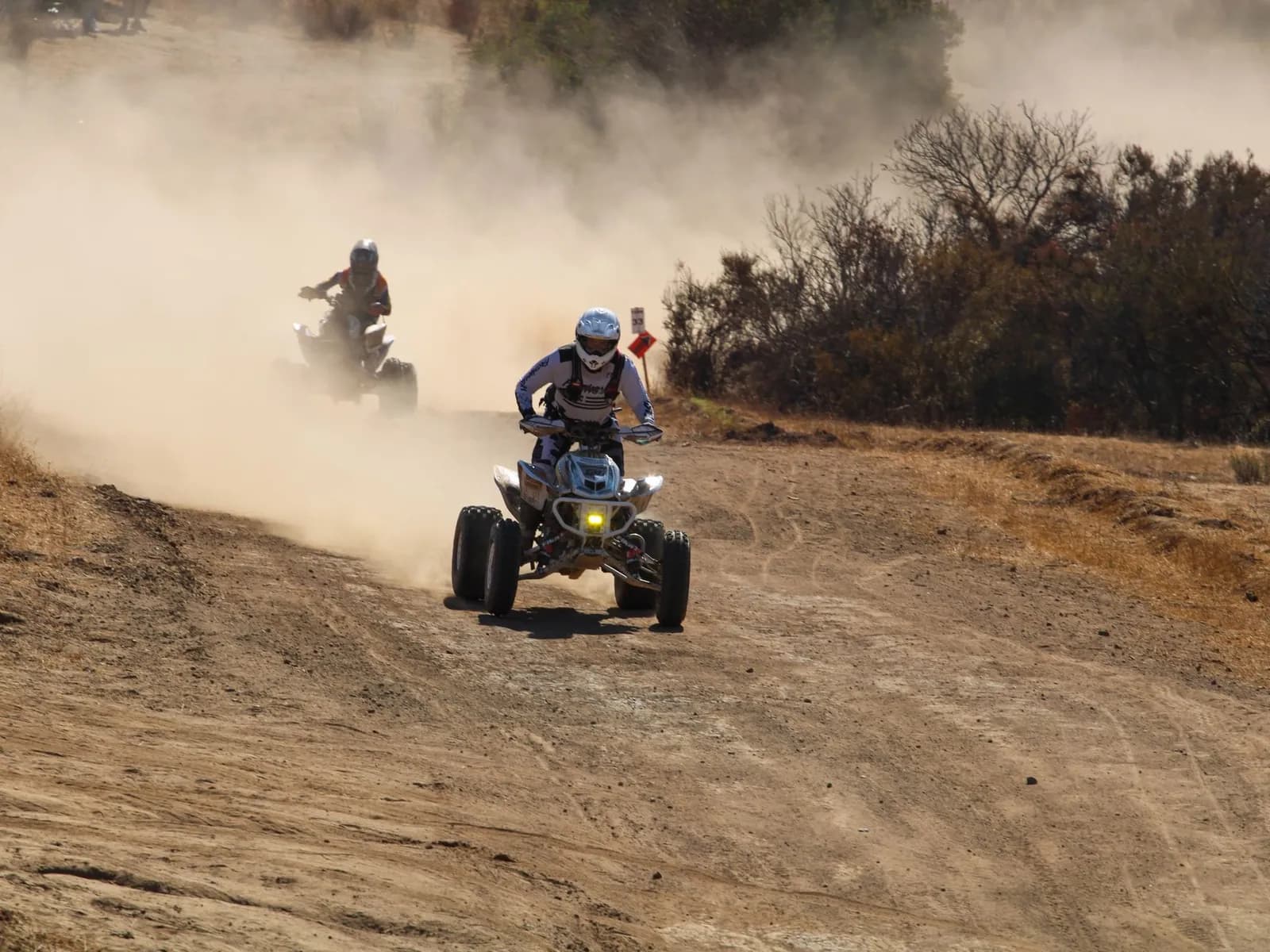 Quads levantando polvo en una pista de tierra