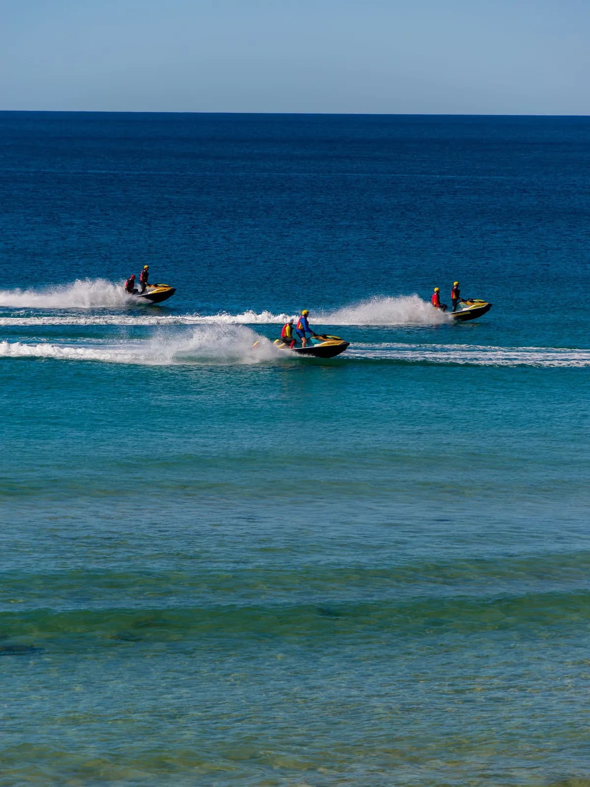 Grupo de motos de agua navegando en fila por mar abierto