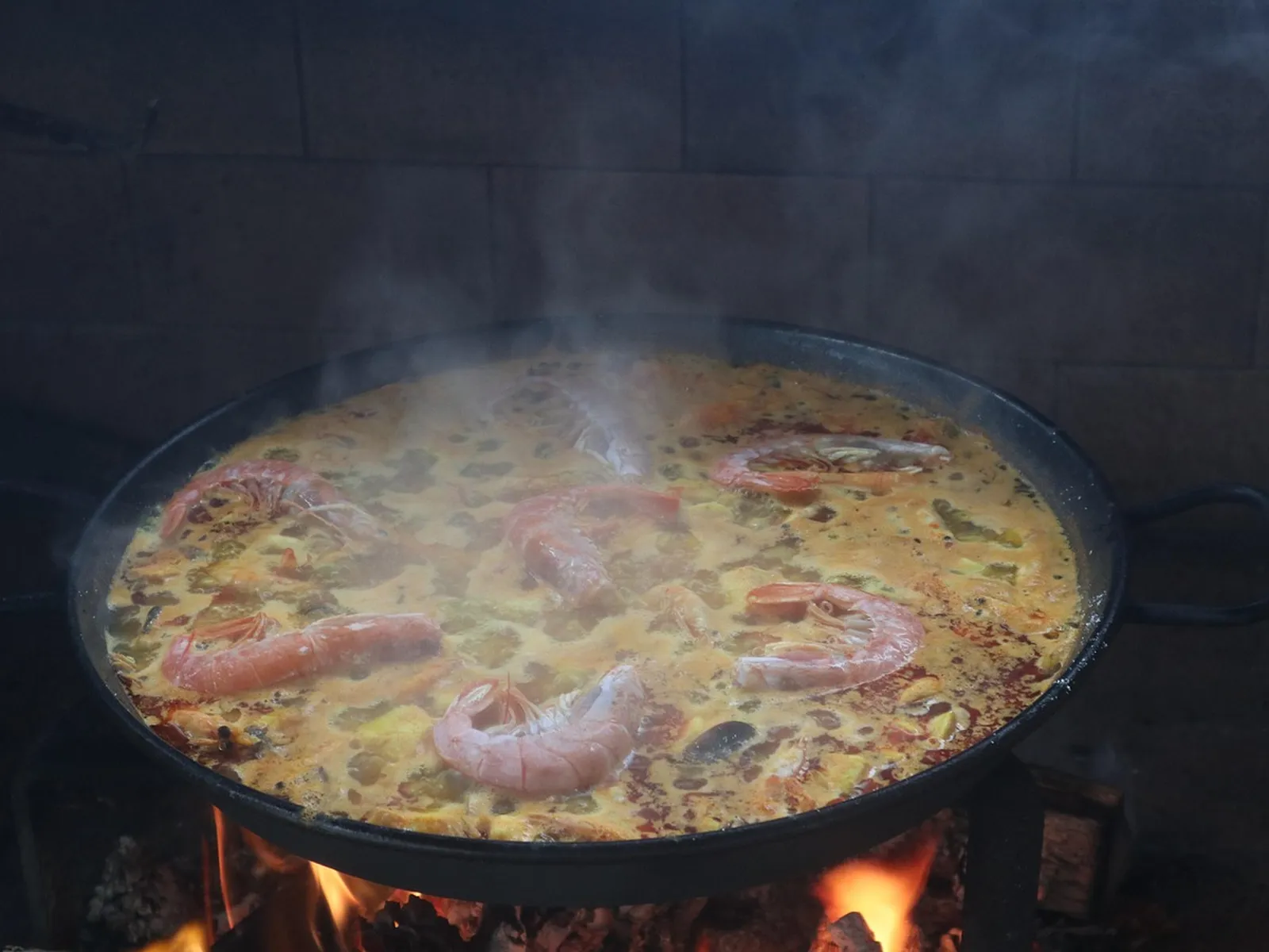 Seafood paella cooking over an open fire