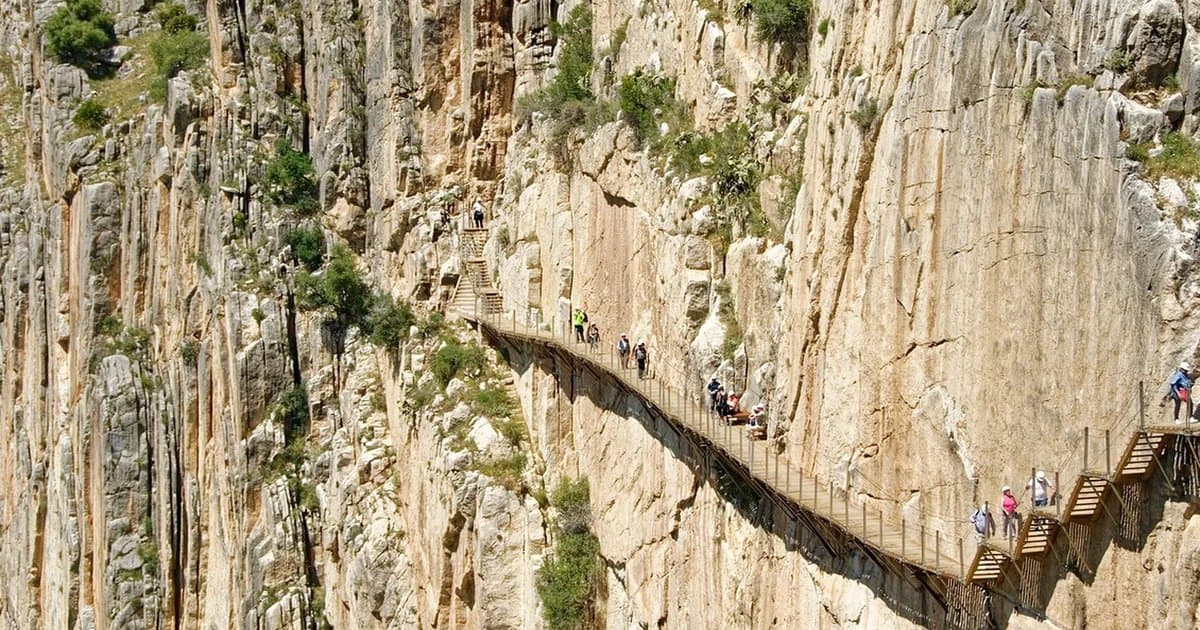 Visitantes recorriendo la pasarela del Caminito del Rey, anclada a la pared vertical del desfiladero de los Gaitanes
