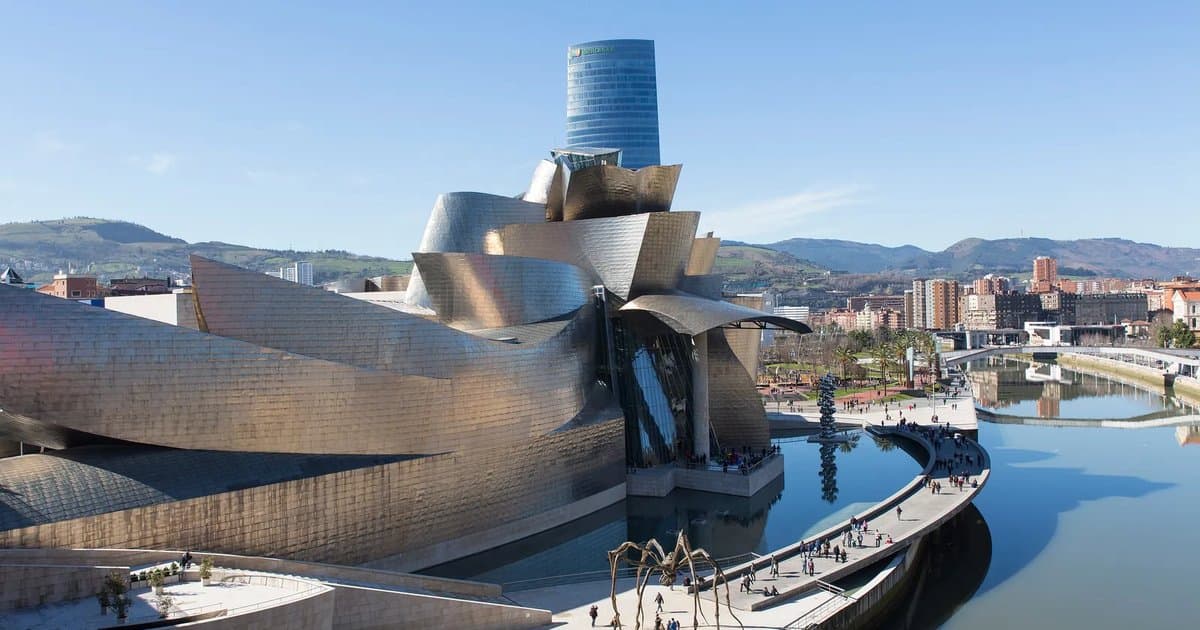 Edificio del Museo Guggenheim Bilbao junto a la ría del Nervión, con sus curvas de titanio