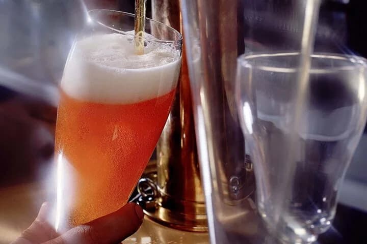 Glass of craft beer being poured from the tap