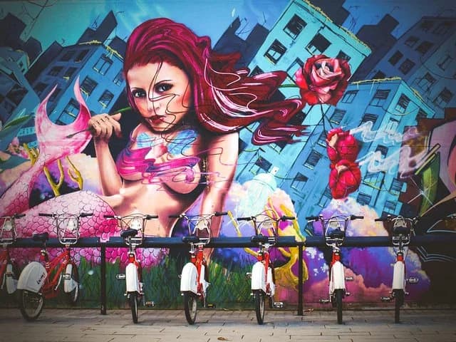 Mural de arte urbano con bicicletas aparcadas delante en Barcelona