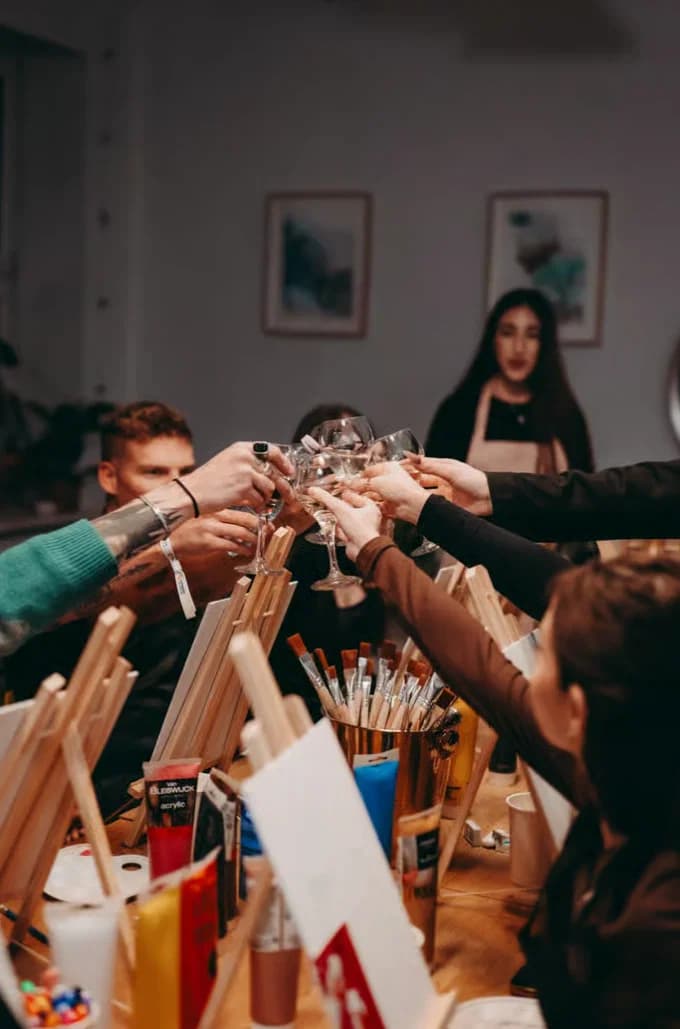 Group raising their glasses in a painting studio